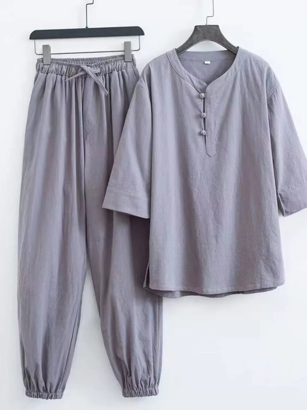 Gray relaxed fit Chinese-inspired men's pants set with drawstring waist and button-up top.