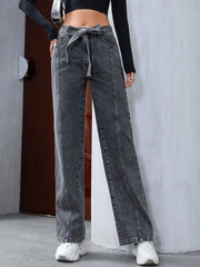 Belted wide-leg washed denim trousers in dark gray with a tie waist and seam detail.