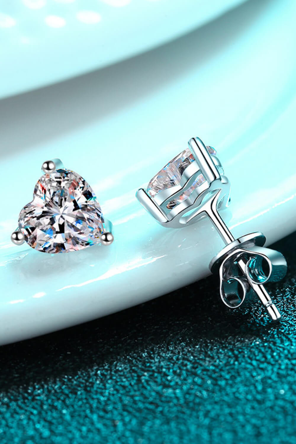 Silver heart-cut moissanite stud earrings with a classic prong setting.