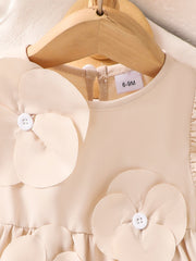 Off-white baby dress with flower appliqués and ruffle sleeves.