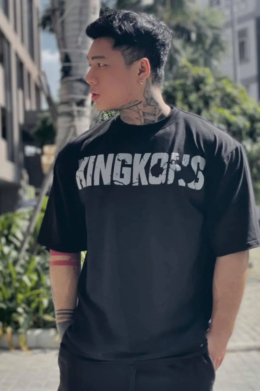 Black oversized graphic tee with distressed "KINGKONG'S" print and crew neck.