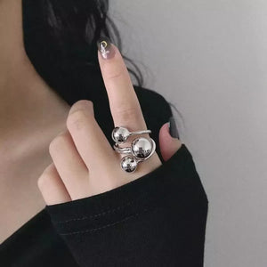 Silver multi-layered ball ring with a modern, abstract design.