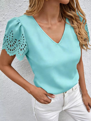 Aqua v-neck blouse with cutout lace detail on short sleeves and puff sleeves.
