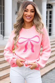 Graphic bow intarsia sweater in blush pink acrylic with a crew neck and long sleeves.