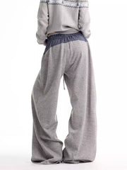 Grey sweatpants with wide legs and a blue checkered waistband detail.
