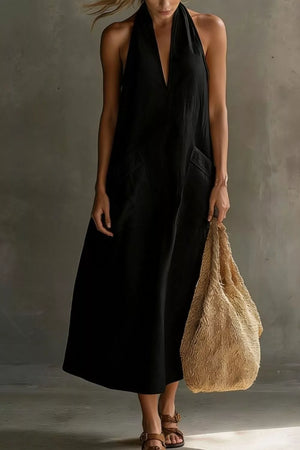 Black halter midi dress with V-neck, pockets, and flowing skirt.