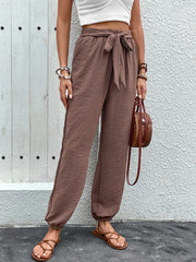Brown textured tie-waist jogger trousers with elastic cuffs.