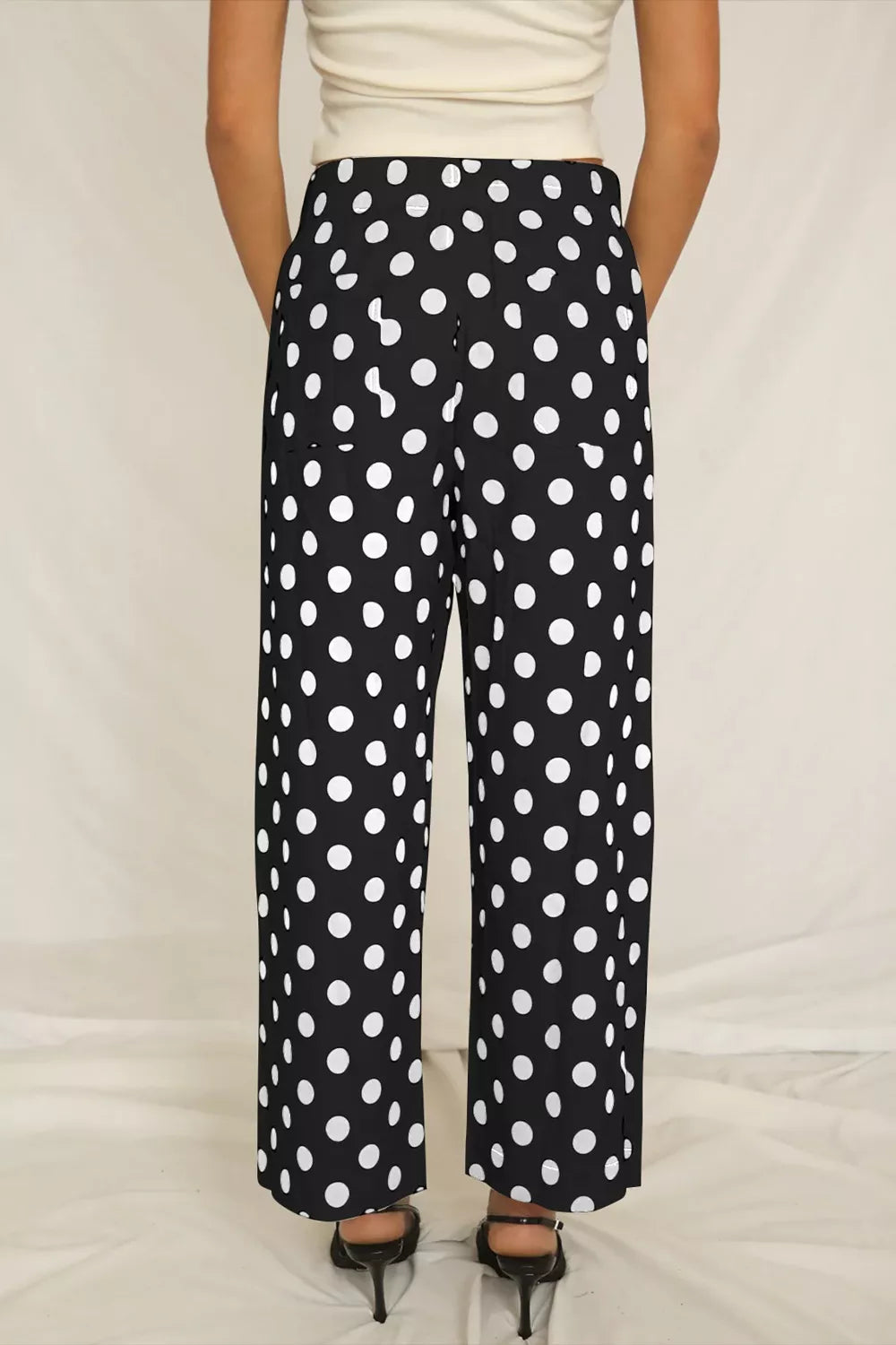 Black polka dot wide leg trousers with pockets and a mid-rise waist.