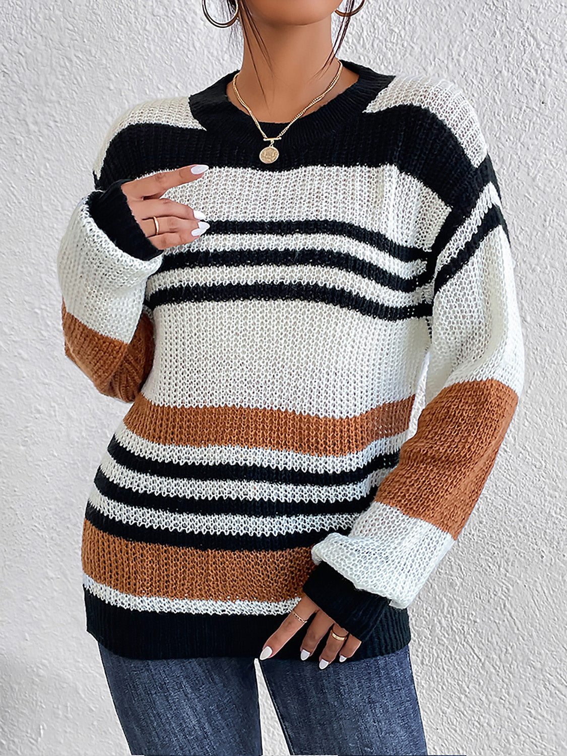 Colorblock stripe knit crewneck sweater in caramel, black, and white acrylic with a relaxed fit.