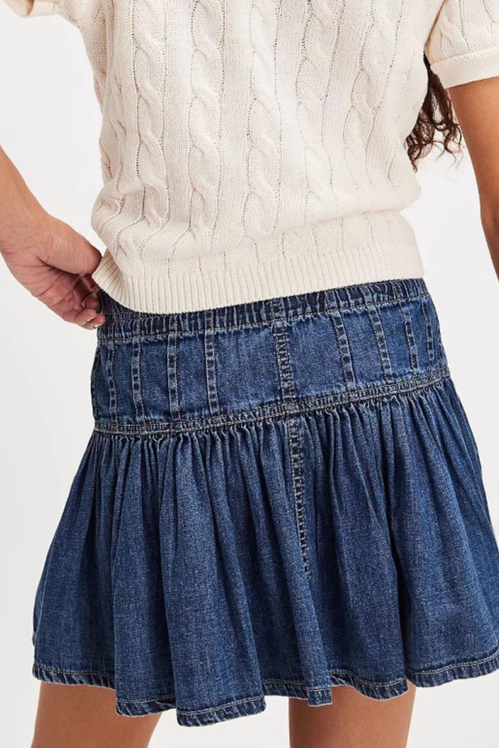 Denim ruffle mini skirt in light blue with elastic waist and tiered design.