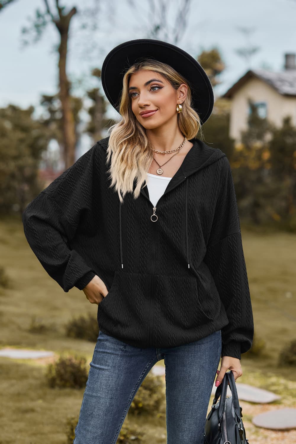 Black textured cable knit zip-up hoodie with drawstring hood and pockets.