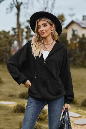 Black textured cable knit zip-up hoodie with drawstring hood and pockets.