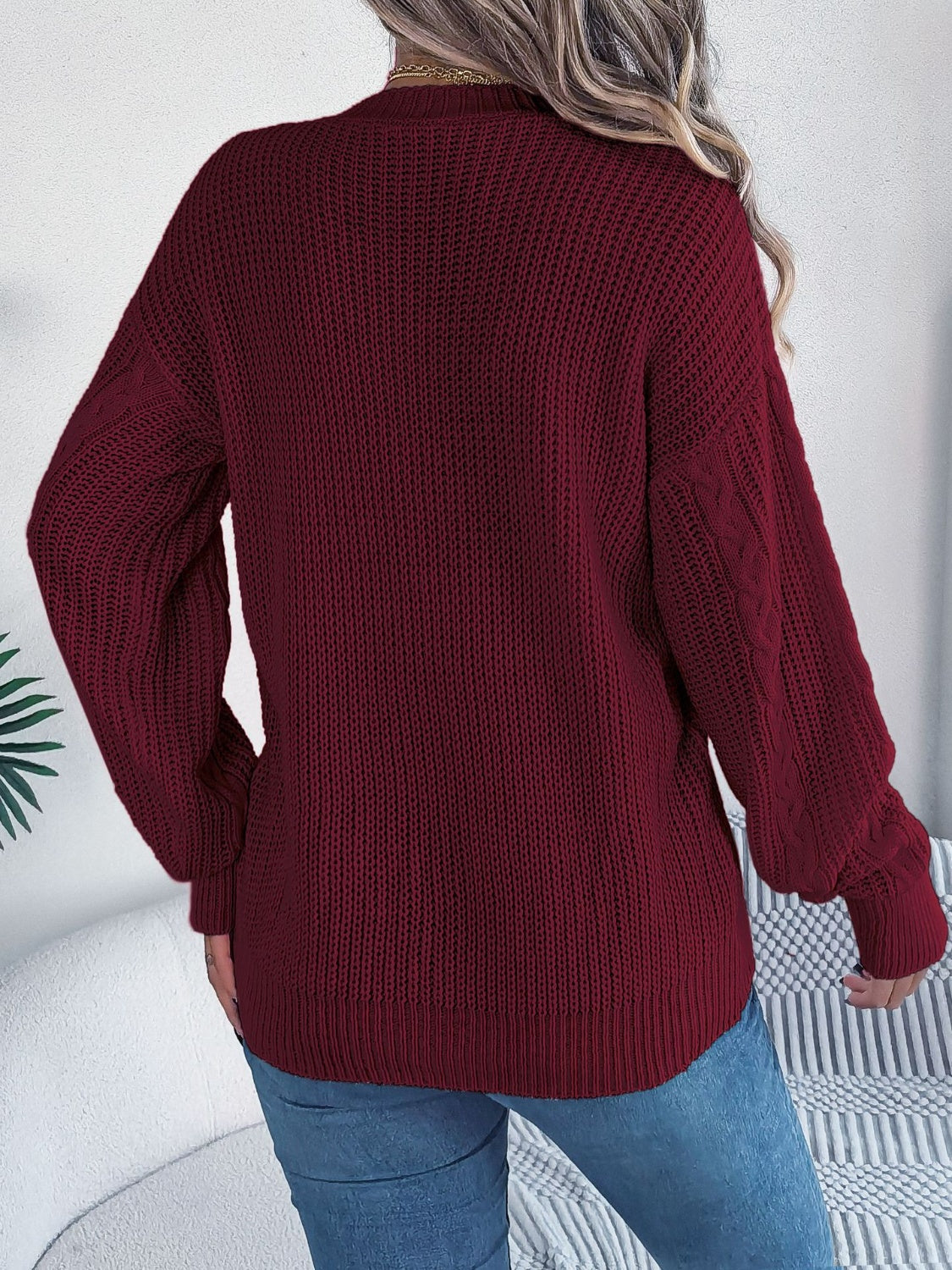 Burgundy cable knit cardigan with balloon sleeves and buttoned front.