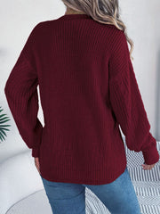 Burgundy cable knit cardigan with balloon sleeves and buttoned front.