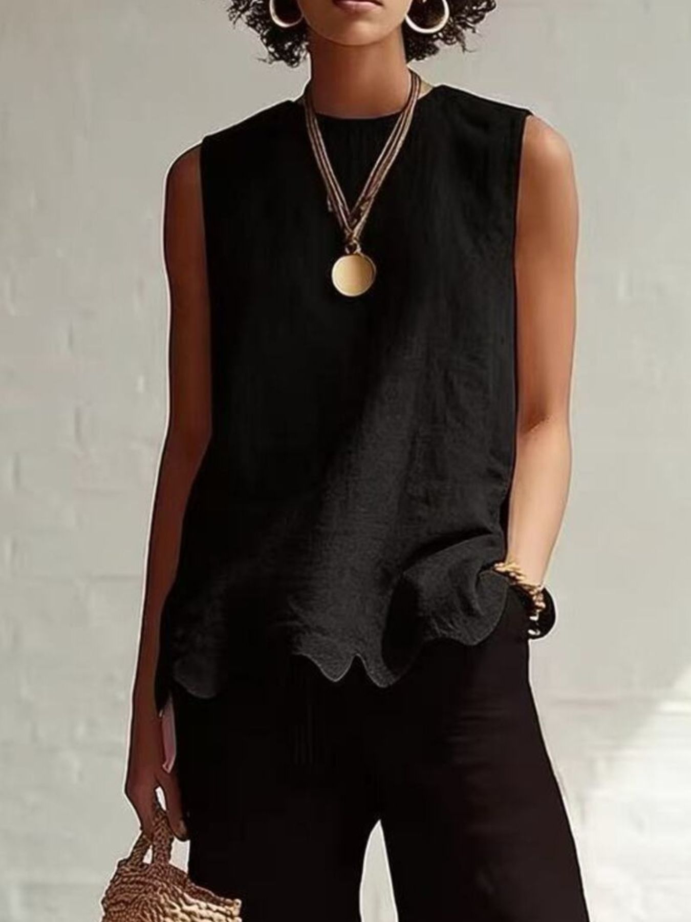 Black sleeveless tank top with scalloped hem detail.