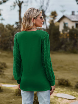 Green Swiss dot sleeve V-neck blouse with long puff sleeves.
