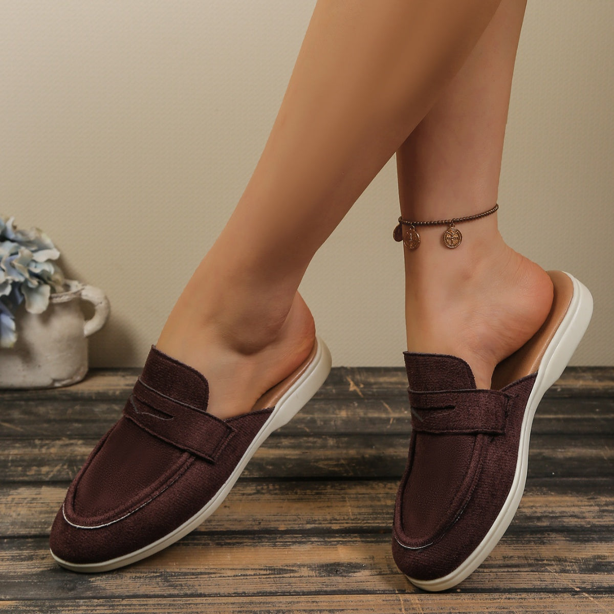 Brown textured round toe slip-on loafers with a backless design and white sole.