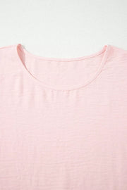 Blush pink polyester blouse with short sleeves and a ruffled neckline.