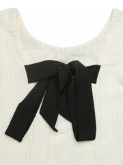 White crinkled texture t-shirt with black bow detail on neckline.