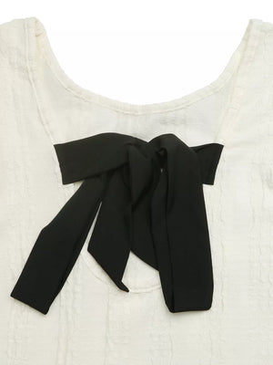 White crinkled texture t-shirt with black bow detail on neckline.