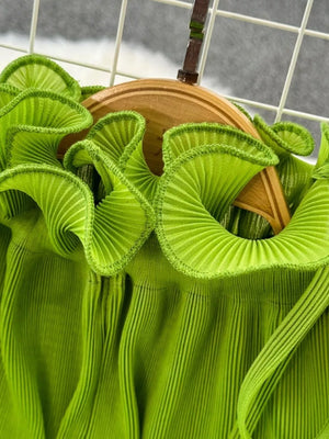 Lime green pleated midi dress with ruffled neckline and belted waist detail.