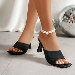 Black knitted mesh open-toe block heel sandals with a pearl anklet.