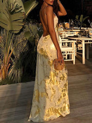 Cream maxi dress with abstract gold pattern, V-neck, and backless design.