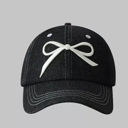 Black baseball cap with white embroidered bow accent