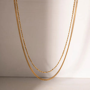 Gold dual-strand curb chain necklace with a twisted rope chain layer.