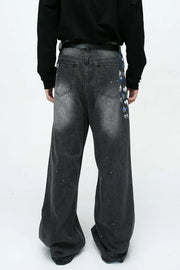 Dark wash wide leg jeans with painterly brushstroke detail and paint splatters.