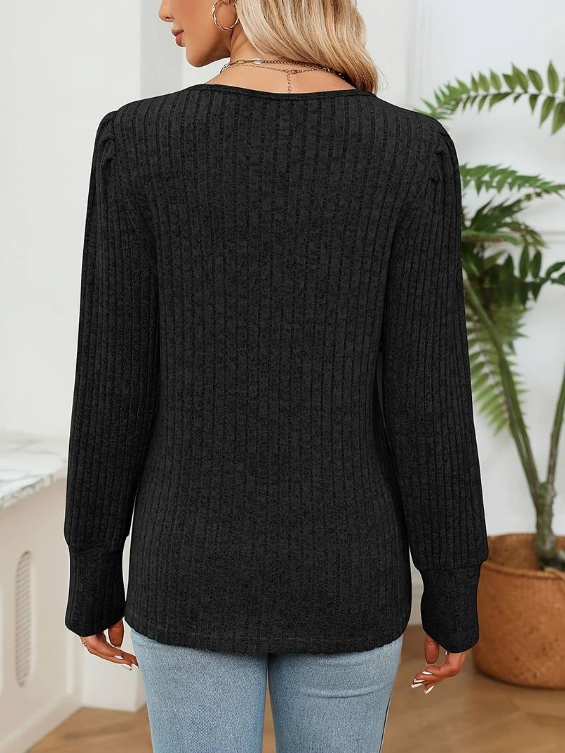 Black ribbed knit sweater with lace trim detail and long sleeves.