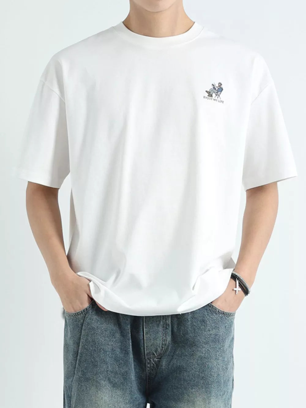 Men's white cotton graphic tee with small chest print and relaxed fit.