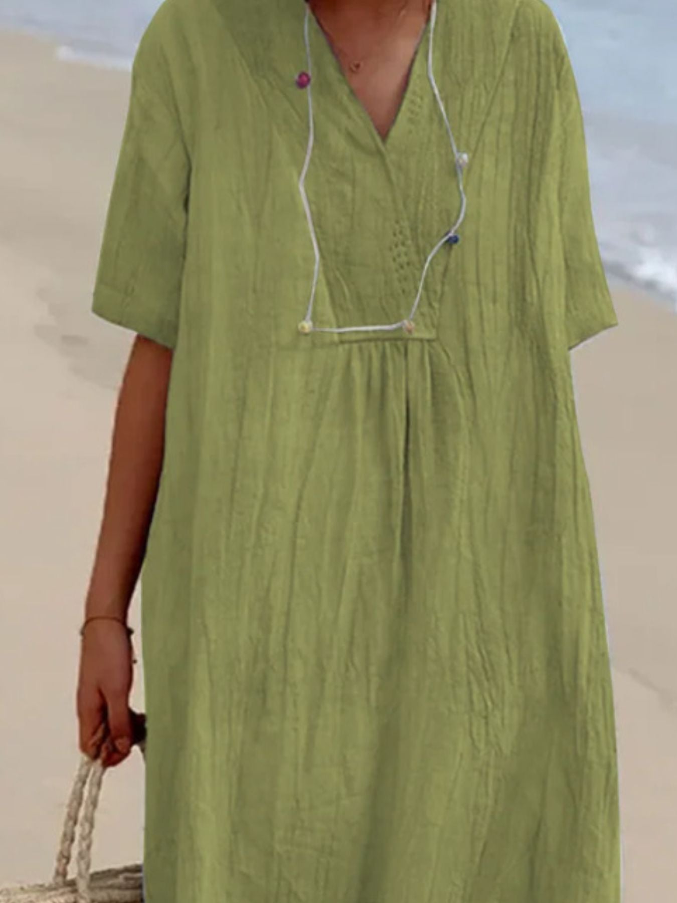 Light green V-neck casual midi dress with short sleeves and textured fabric.