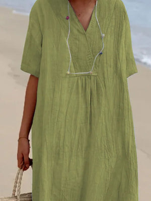 Light green V-neck casual midi dress with short sleeves and textured fabric.