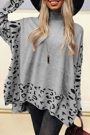 Gray turtleneck sweater with asymmetric leopard print panels and a high-low hem.