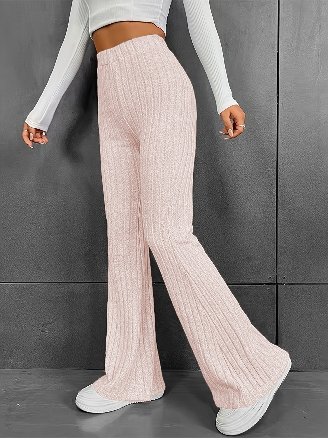 Blush pink ribbed flare trousers in 100% polyester with a high waist and bootcut leg.