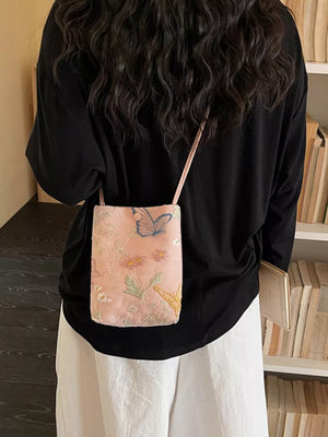 Pink embroidered mini crossbody bag with butterflies and floral details.