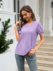 Lavender eyelet puff sleeve v-neck blouse with textured pattern.