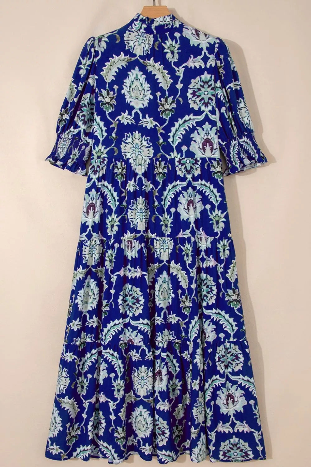 Maxi dress with blue floral print, frilled collar, tiered skirt, and puff sleeves.