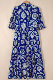 Maxi dress with blue floral print, frilled collar, tiered skirt, and puff sleeves.