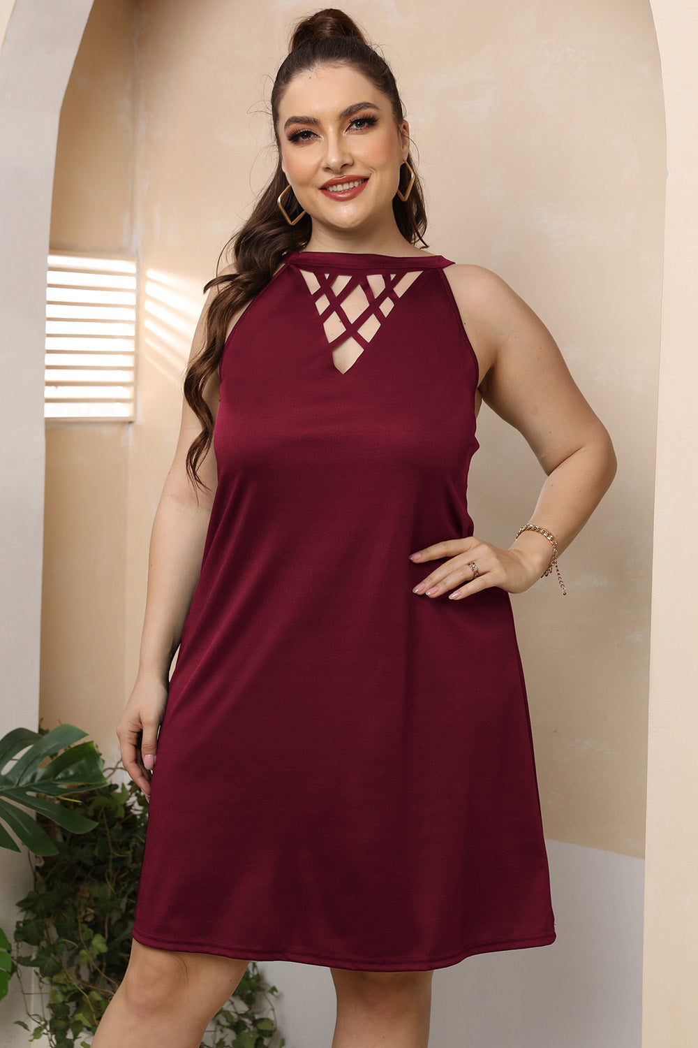 Wine trapeze mini dress with crisscross halter neckline and sleeveless cut.