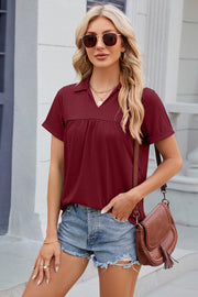 Burgundy polo top with gathered yoke and short sleeves.