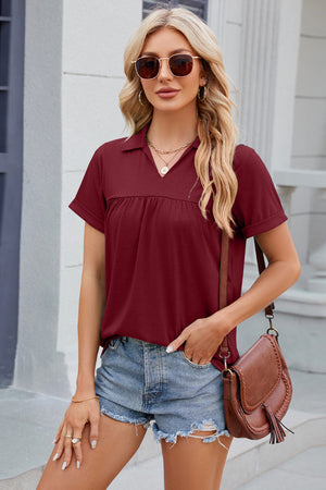 Burgundy polo top with gathered yoke and short sleeves.