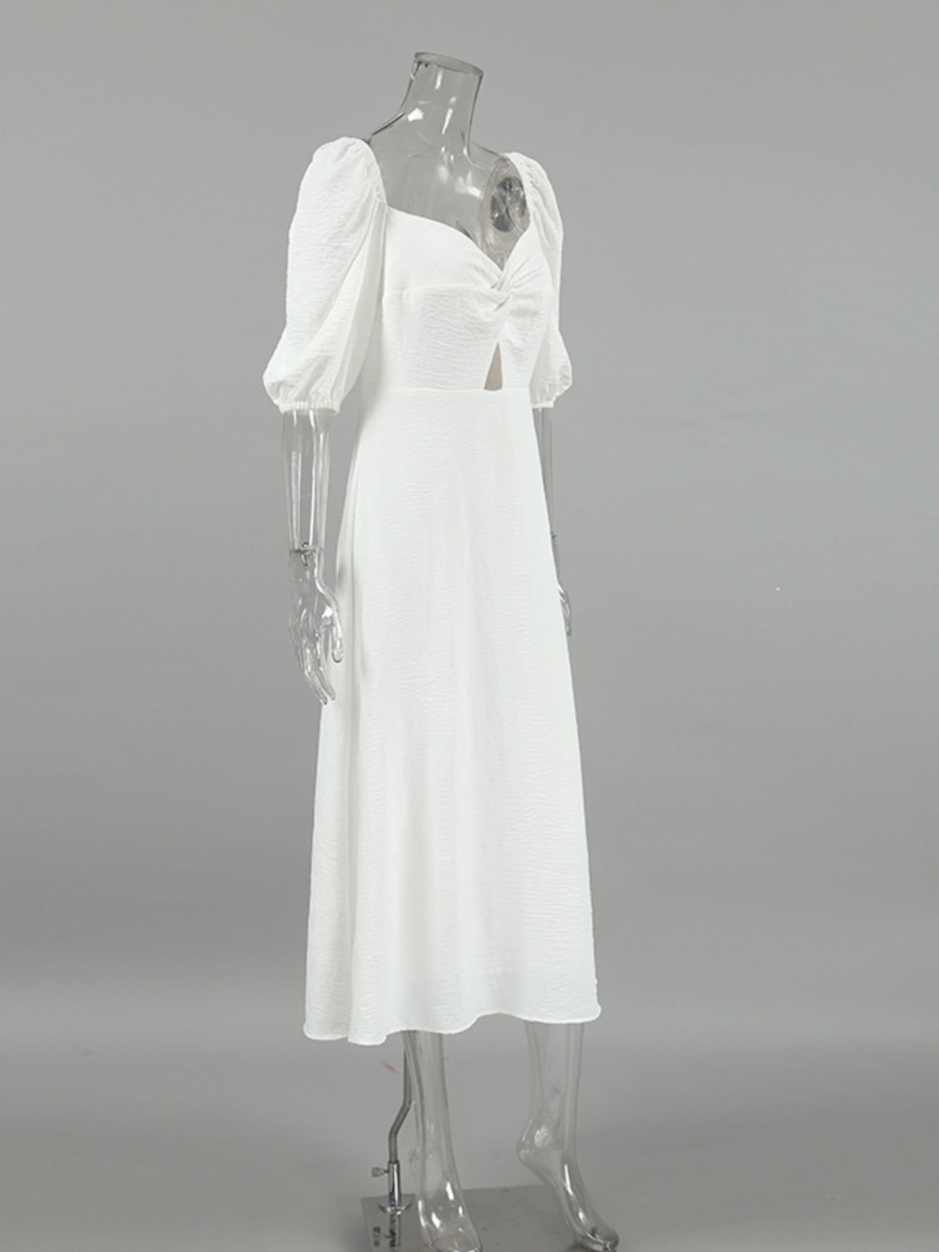 White midi dress with sweetheart neckline, puff sleeves, cutout detail and twisted front.