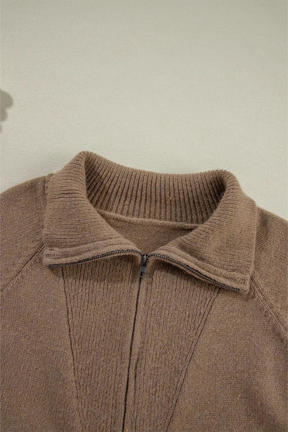 Taupe knit zip-through jacket with a collared neckline and ribbed details.