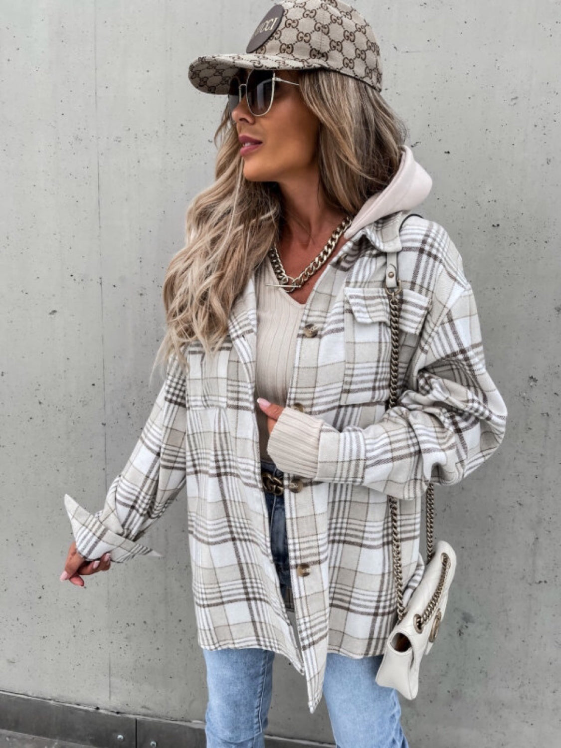 Oversized plaid shacket with attached hood in beige and white, featuring buttoned front and cuffs.