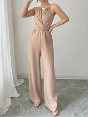 Beige halter neck wide leg jumpsuit with a crossover bodice and drawstring waist.