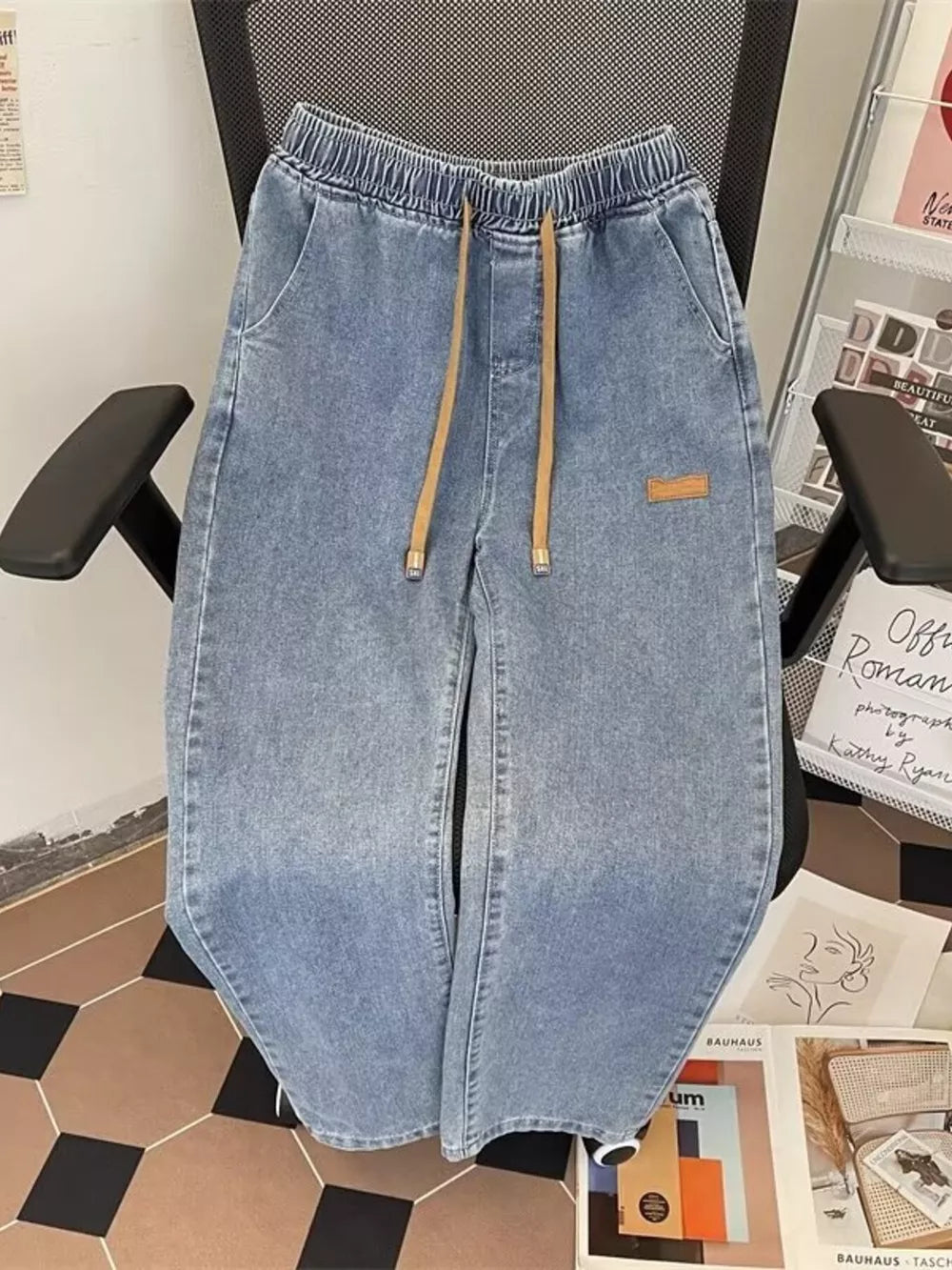 Light blue wide-leg jeans with drawstring waist and side pockets.
