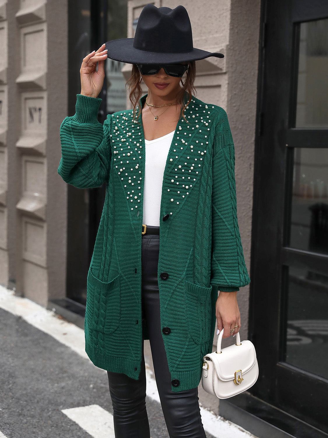 Emerald cable knit cardigan with pearl embellishments and pockets.