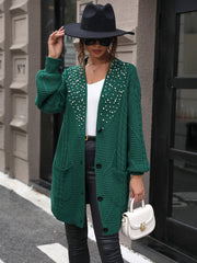 Emerald cable knit cardigan with pearl embellishments and pockets.